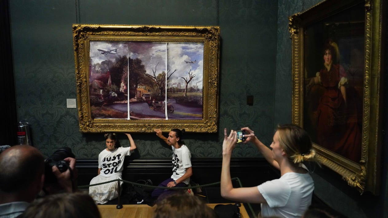 Klimaaktivister fra Just Stop Oil limer seg fast til «Hay Wain» (1821) av John Constable på National Gallery i London. (Foto: Just Stop Oil.)