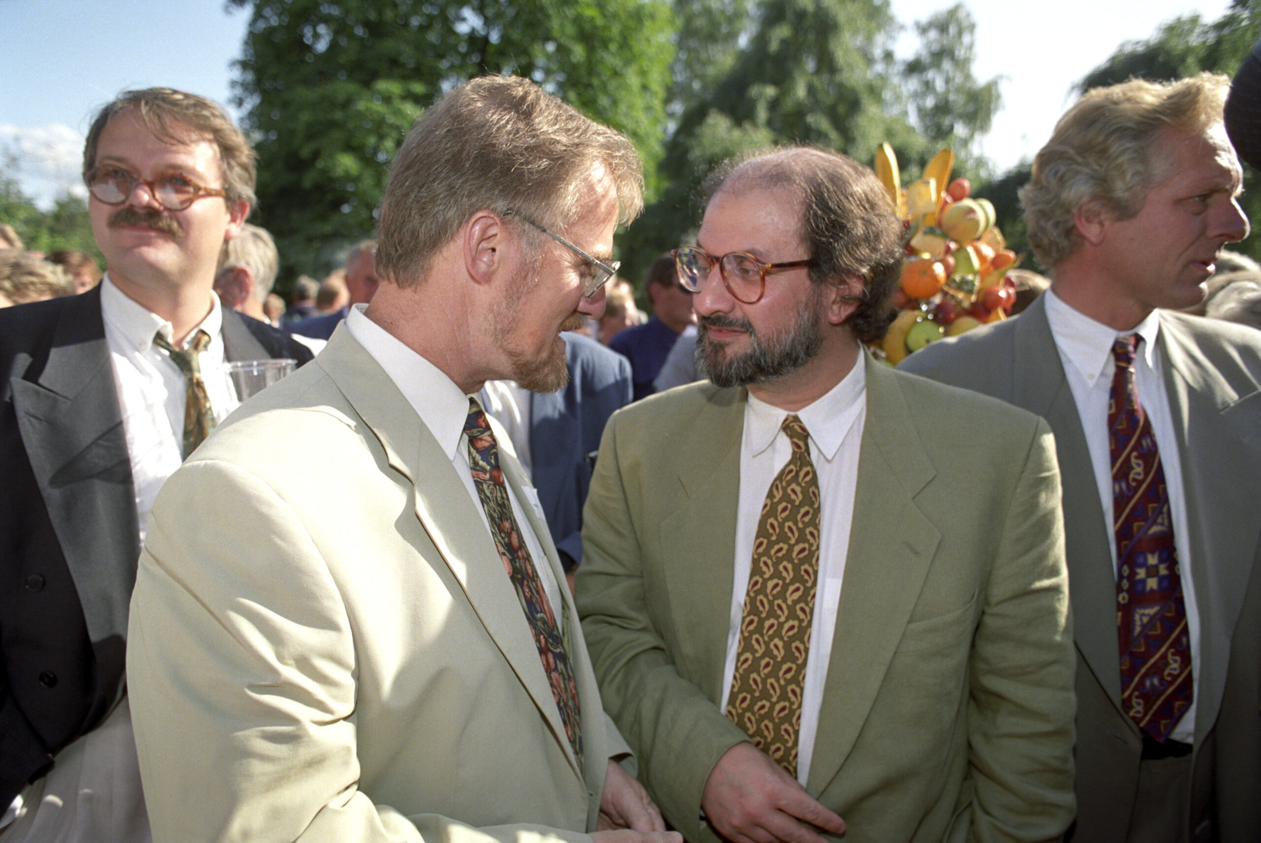 Forfatter Salman Rushdie under den tradisjonelle hagefesten til Aschehougs forlag. Her i samtale med undervisningsminister Gudmund Hernes. William Nygaard (t.h.). (Foto: Lise Åserud NTB/NTB.)