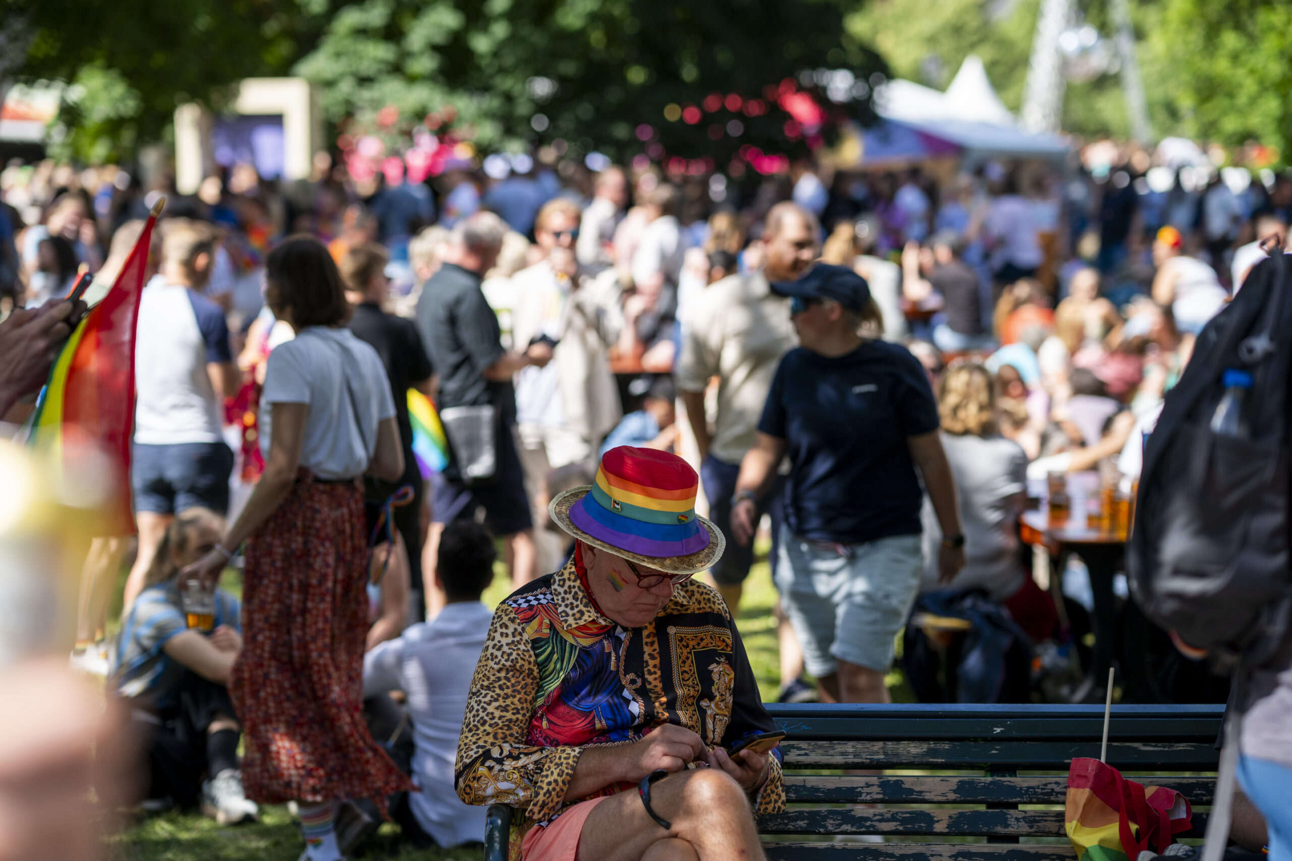 Oslo 20240629. En person med pride hatt sitter på en benk i Sofienberg parken hvor Pride Park blir arrangert etter. Pride-paraden, som feirer skeivt mangfold, markerer uoppnådde rettigheter og forsvarer eksisterende rettigheter, går fra Grønland til Pride Park i Sofienbergparken i Oslo lørdag. (Foto: Frederik Ringnes/NTB.)